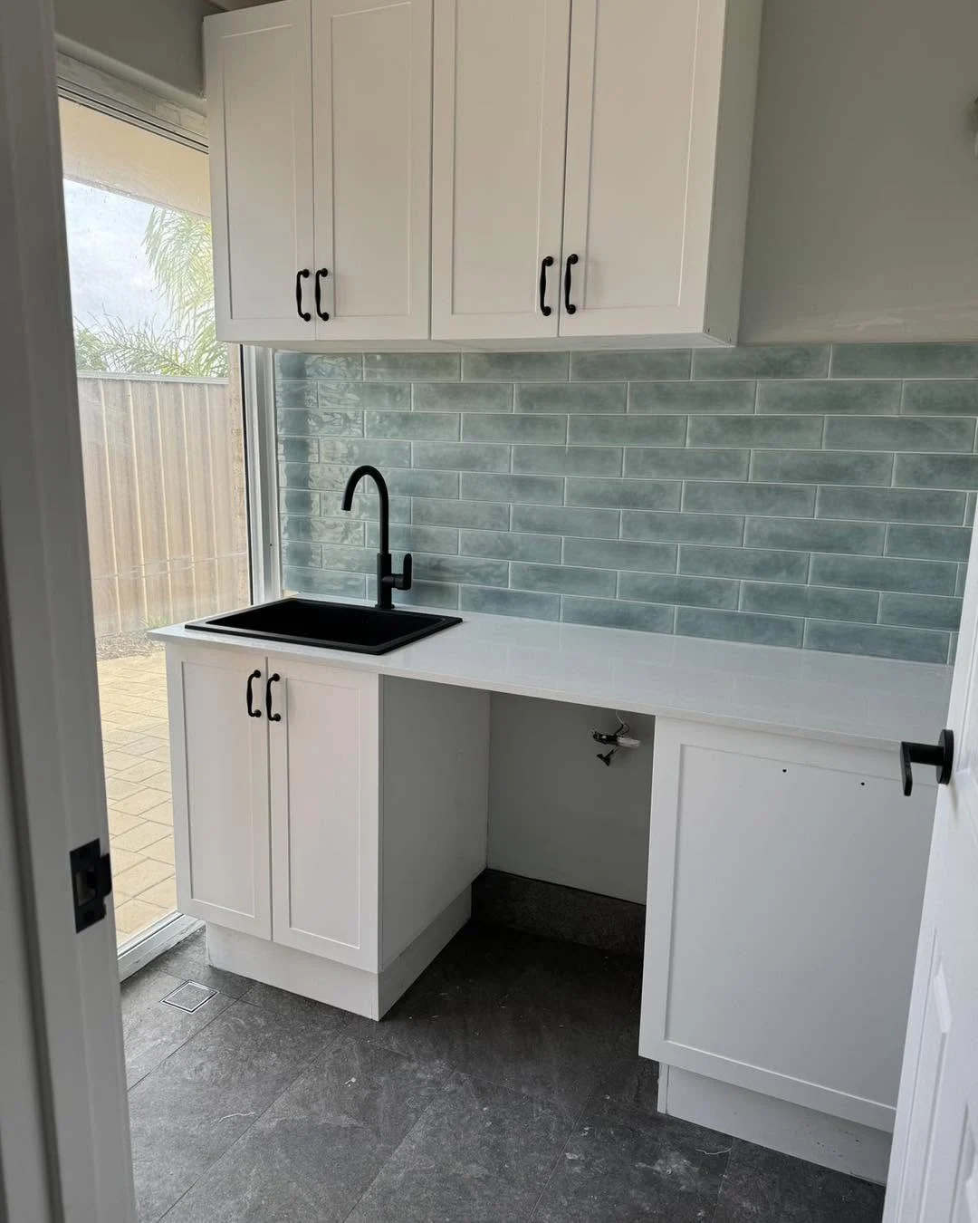 Laundry with tiled splashback